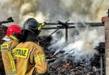 Niebezpieczny pożar w Laskach. Odważny strażak wyniósł rozgrzane beczki z łatwopalną substancją